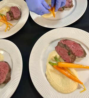 Freunde genießen ein kulinarisches Erlebnis mit einem Privatkoch in moderner Küche