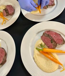 Freunde genießen ein kulinarisches Erlebnis mit einem Privatkoch in moderner Küche