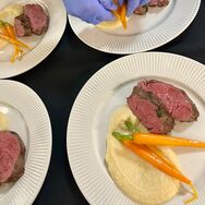 Freunde genießen ein kulinarisches Erlebnis mit einem Privatkoch in moderner Küche